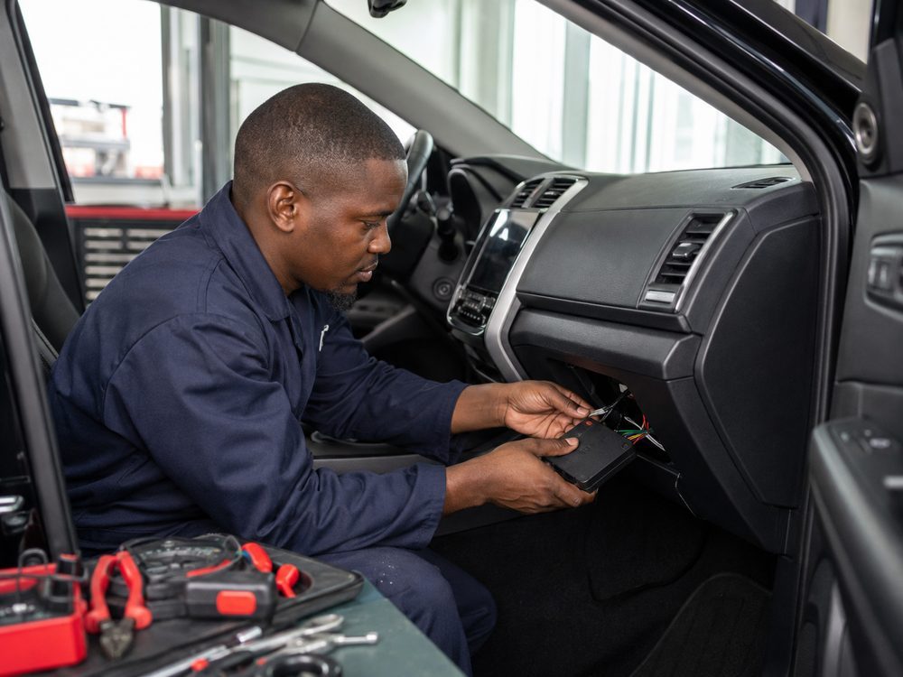 TrailMyCar technician installing a GPS tracking device in a vehicle